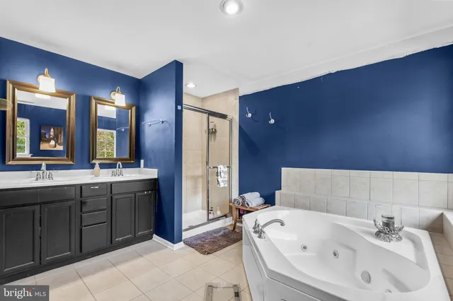 a bathroom with a tub sink and mirror