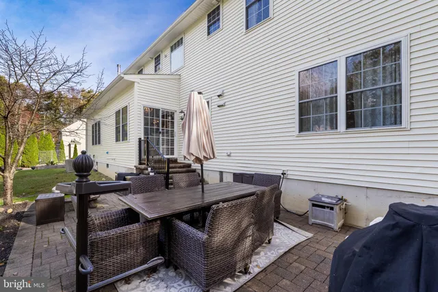 a view of a patio with couches and table and chairs with floor to ceiling window and wooden fence