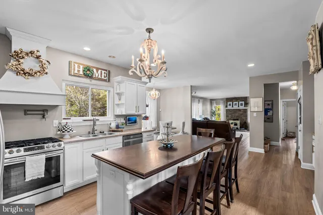 a kitchen with stainless steel appliances a dining table and chairs