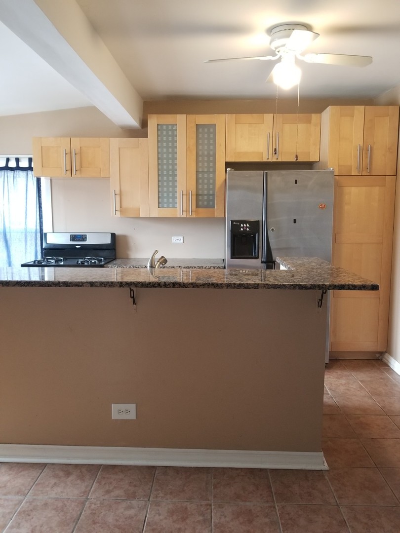 4019 North Tripp Avenue Chicago, IL 60641 - Photo 12 of 31 a kitchen with granite countertop a sink a stove and cabinets
