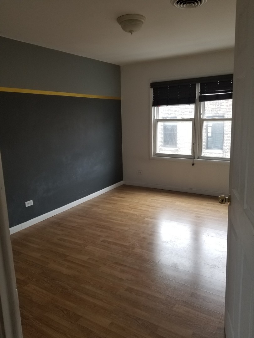 4019 North Tripp Avenue Chicago, IL 60641 - Photo 17 of 31 an empty room with wooden floor and windows