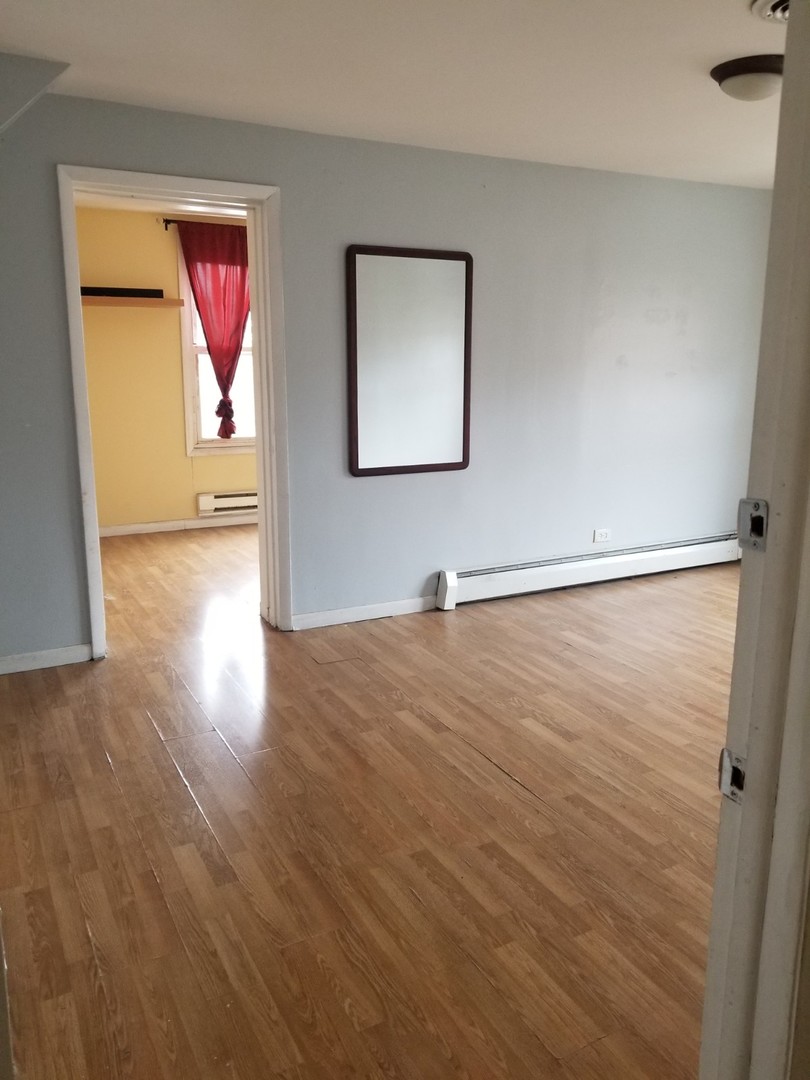 4019 North Tripp Avenue Chicago, IL 60641 - Photo 18 of 31 an empty room with wooden floor and windows