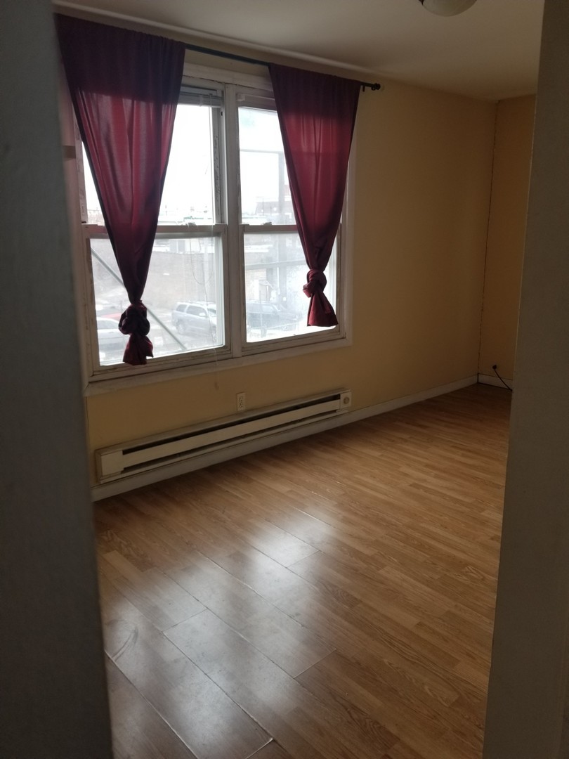 4019 North Tripp Avenue Chicago, IL 60641 - Photo 20 of 31 an empty room with wooden floor and windows