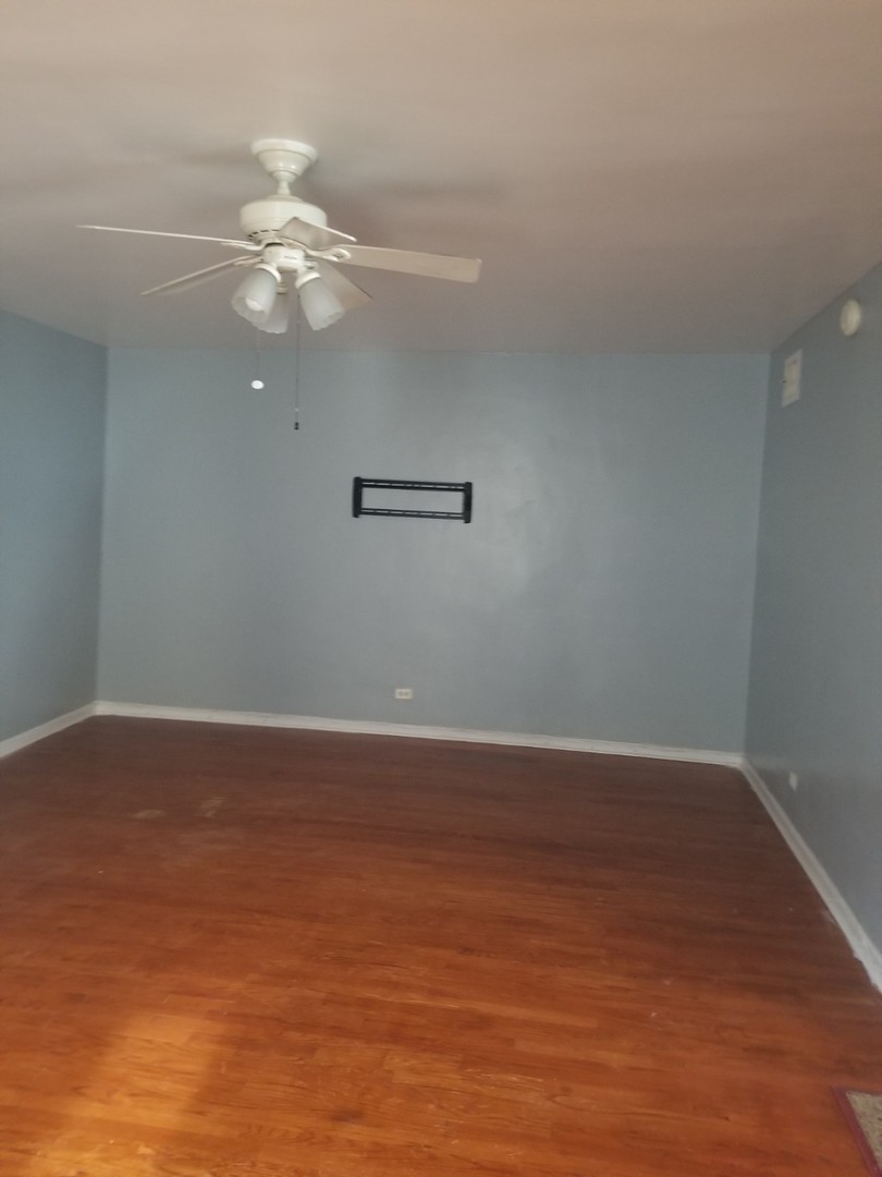 4019 North Tripp Avenue Chicago, IL 60641 - Photo 4 of 31 a view of a room with wooden floor and ceiling fan