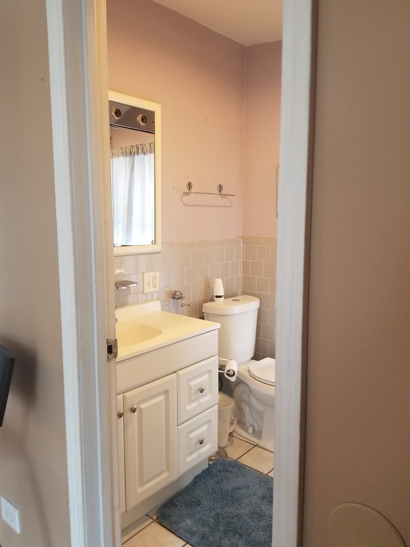 4019 North Tripp Avenue Chicago, IL 60641 - Photo 6 of 31 a bathroom with a toilet a sink and a window