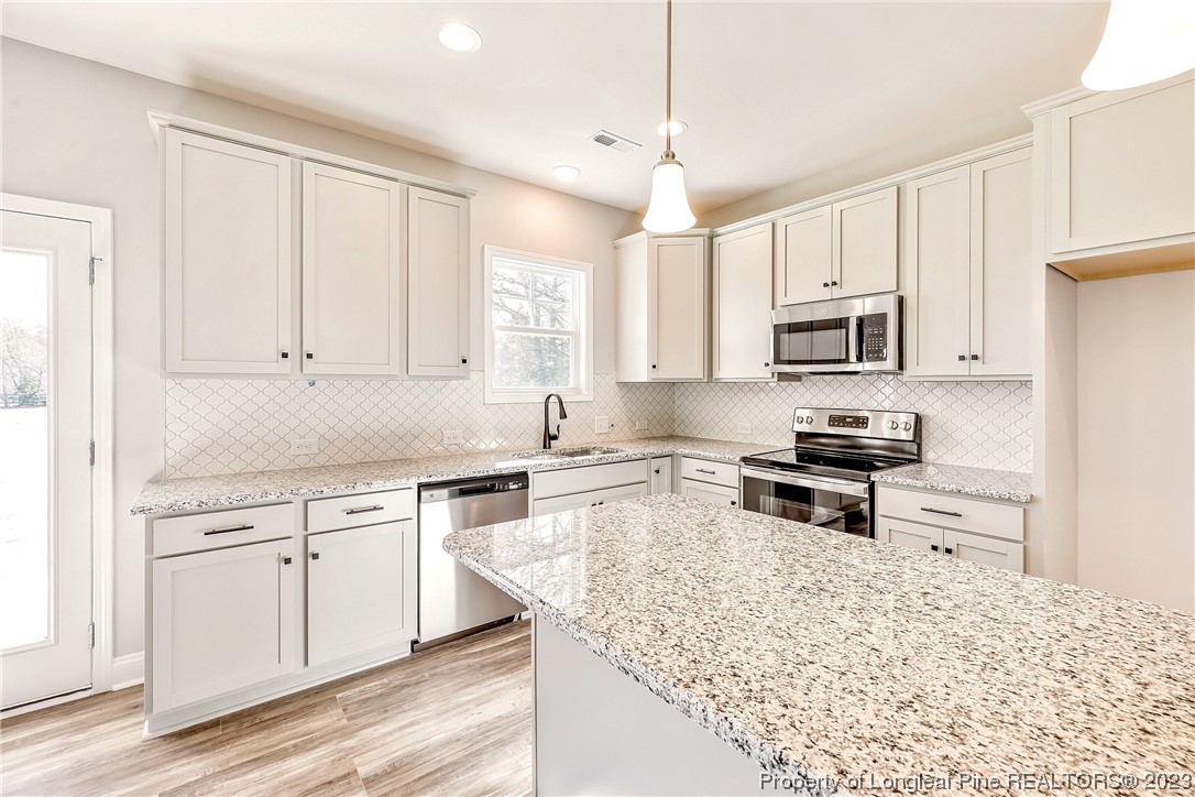 5326 Pittman Grove Church Road Raeford, NC 28376 - Photo 11 of 34 a kitchen with kitchen island white cabinets and refrigerator