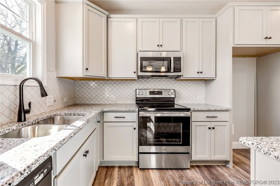 5326 Pittman Grove Church Road Raeford, NC 28376 - Photo 13 of 34 a kitchen with stainless steel appliances granite countertop a sink and a stove