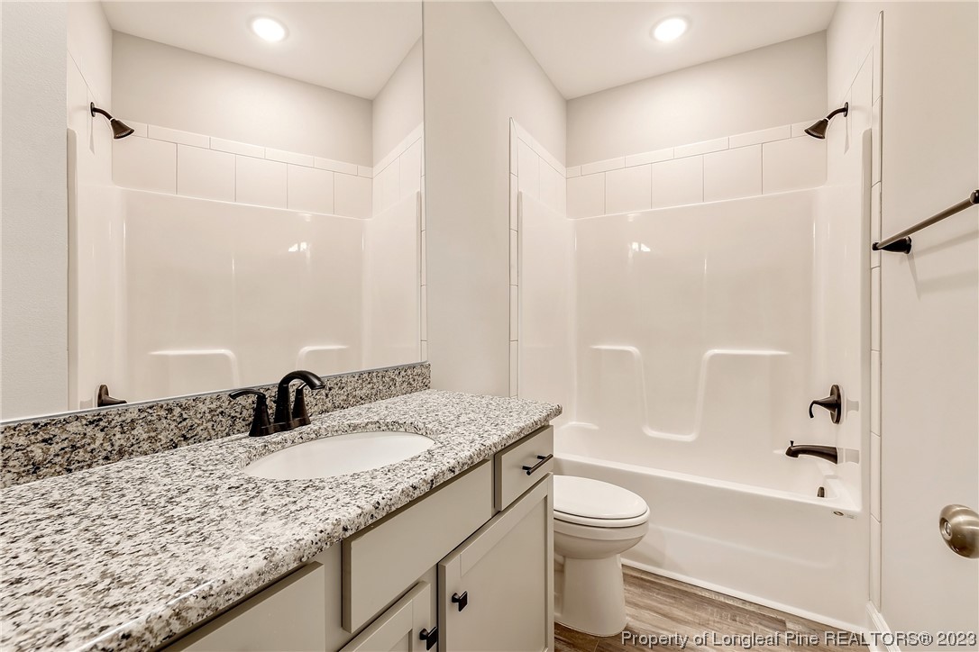 5326 Pittman Grove Church Road Raeford, NC 28376 - Photo 14 of 34 a bathroom with a granite countertop sink a toilet and shower