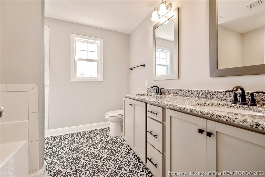 5326 Pittman Grove Church Road Raeford, NC 28376 - Photo 28 of 34 a bathroom with a granite countertop sink toilet and shower