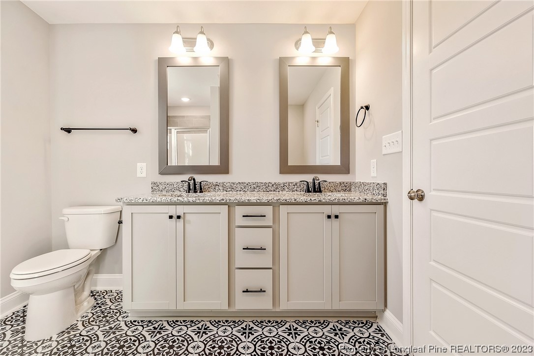 5326 Pittman Grove Church Road Raeford, NC 28376 - Photo 30 of 34 a bathroom with a sink a toilet and a mirror