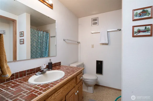 a bathroom with a sink toilet mirror and shower