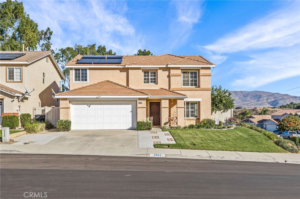 a front view of a house with a garden and plants