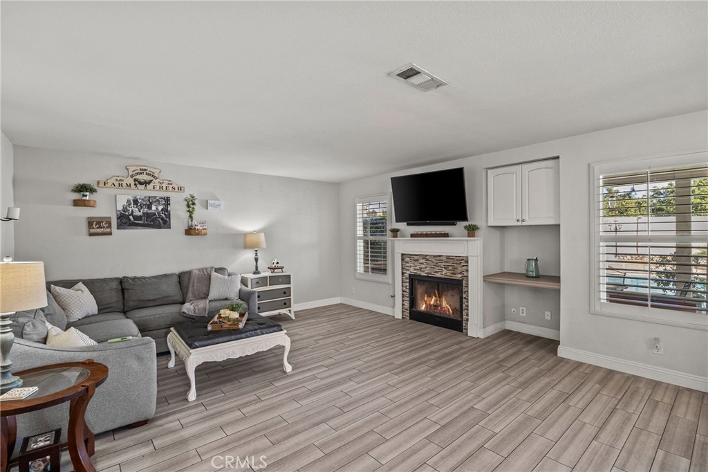8992 Dahlia Drive Corona, CA 92883 - Photo 12 of 38 a living room with furniture a fireplace and a flat screen tv