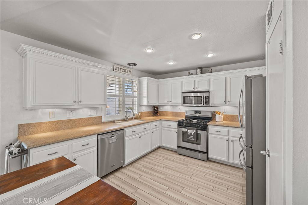 8992 Dahlia Drive Corona, CA 92883 - Photo 7 of 38 a kitchen with a sink stainless steel appliances and cabinets
