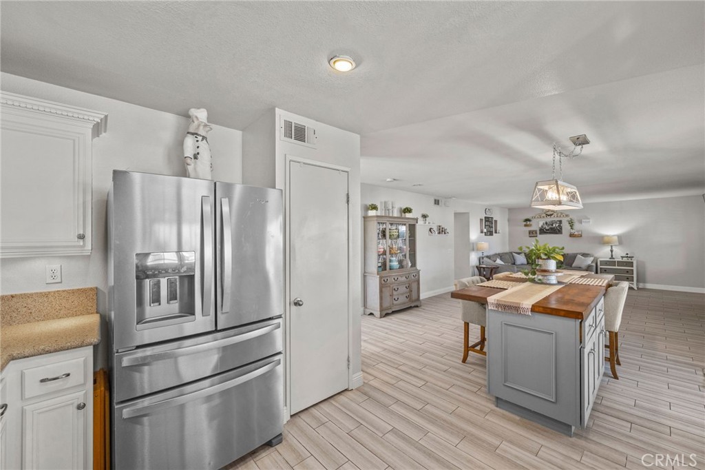 8992 Dahlia Drive Corona, CA 92883 - Photo 8 of 38 a kitchen with stainless steel appliances kitchen island granite countertop a refrigerator stove and sink