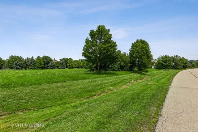a view of a green field with wooden fence