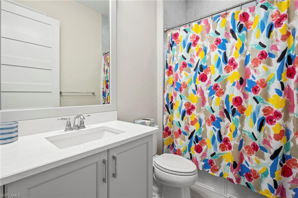 8795 Calypso Court Naples, FL 34113 - Photo 16 of 49 a bathroom with a toilet sink and a mirror