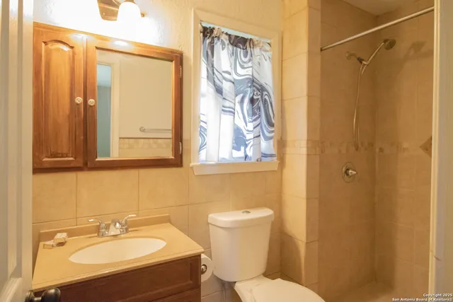 a bathroom with a sink a mirror and a shower curtain