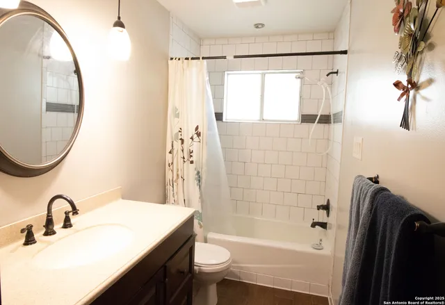 a bathroom with a sink a toilet and a mirror