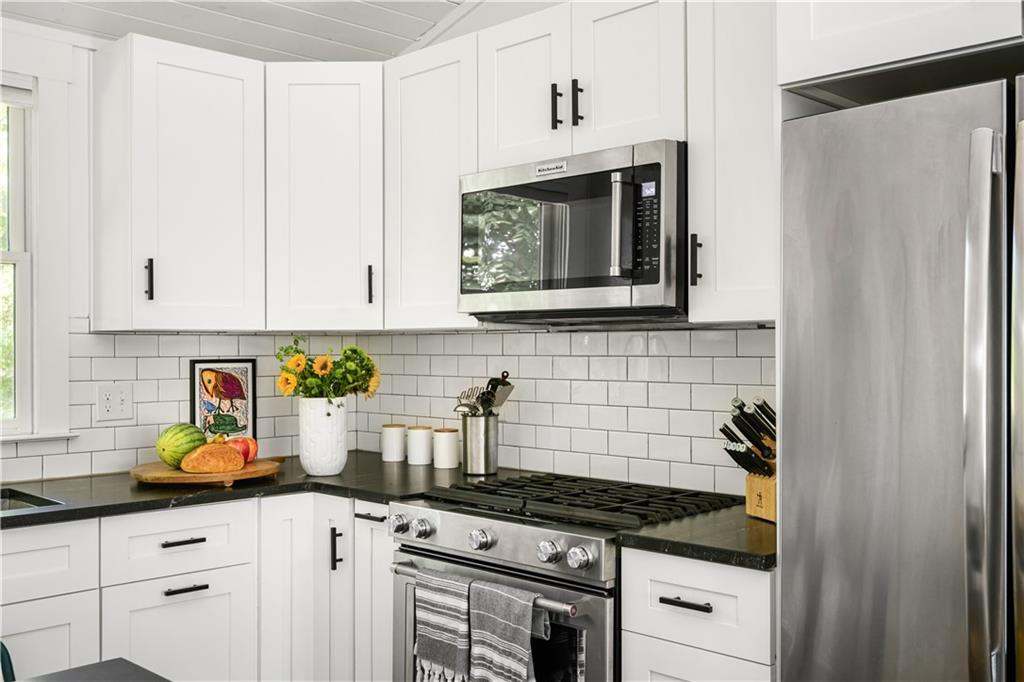 347 Sinclair Avenue Northeast Atlanta, GA 30307 - Photo 12 of 32 a kitchen with stainless steel appliances granite countertop white cabinets and a stove