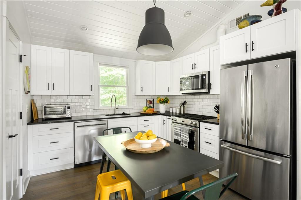 347 Sinclair Avenue Northeast Atlanta, GA 30307 - Photo 3 of 32 a kitchen with stainless steel appliances a stove a refrigerator a sink a stove and white cabinets with wooden floor