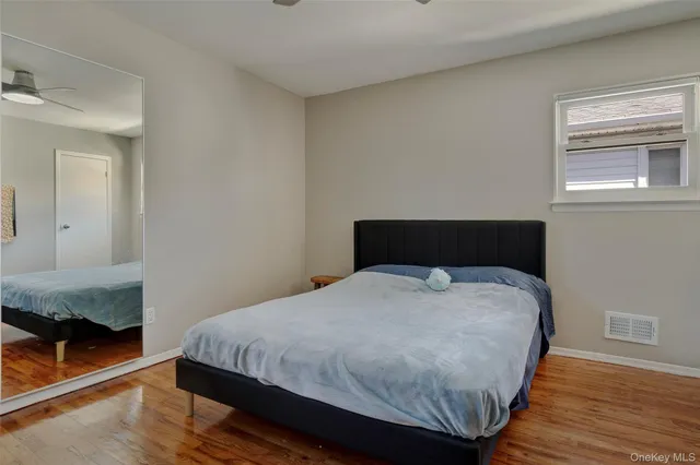 a bedroom with a bed and wooden floor