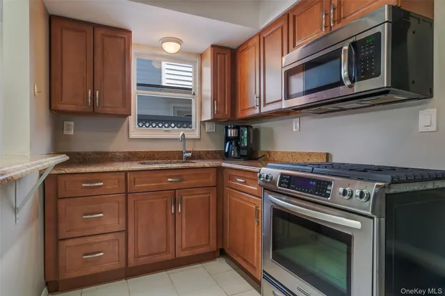 a kitchen with stainless steel appliances granite countertop a stove microwave and cabinets