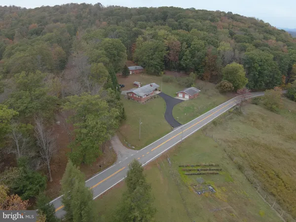a view of a house with a garden and sitting area