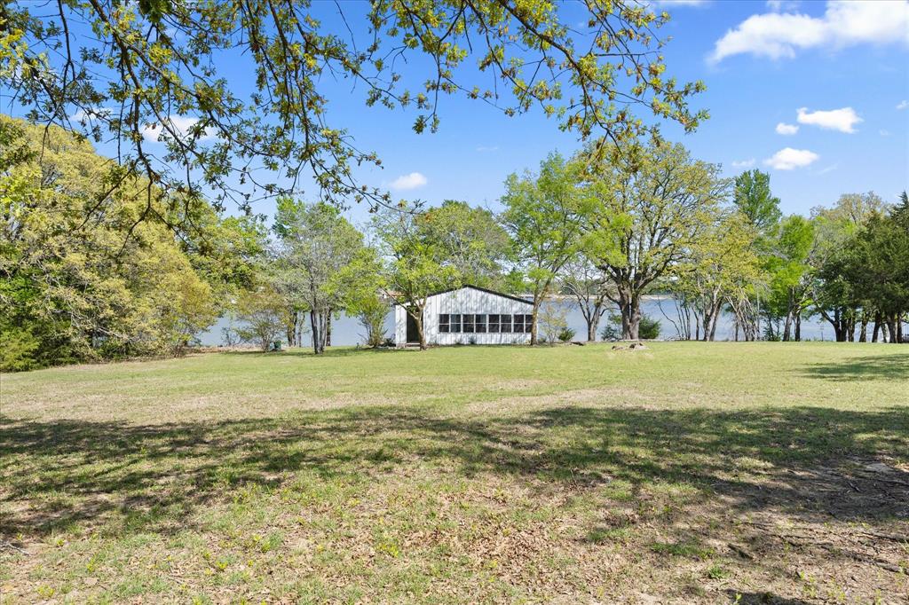 2776 Waters Edge Quinlan, TX 75474 - Photo 26 of 28 a front view of a house with a yard and trees