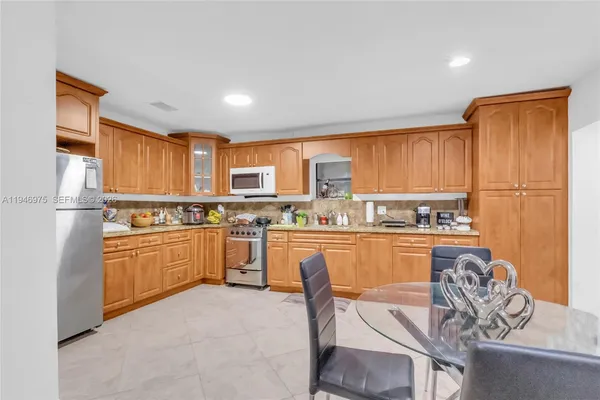 a kitchen with stainless steel appliances a refrigerator and a stove top oven