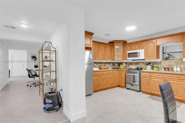 a kitchen with stainless steel appliances a refrigerator and wooden cabinets