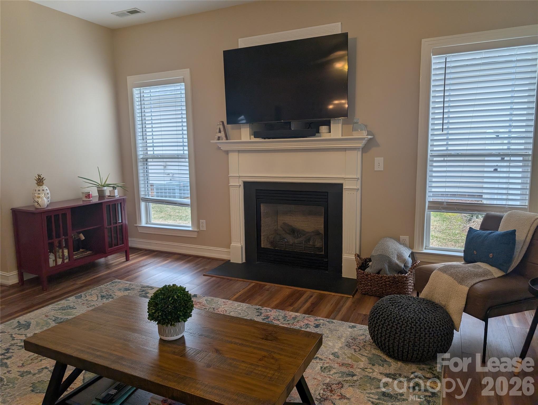 20207 Colony Point Lane Cornelius, NC 28031 - Photo 4 of 26 a living room with furniture a flat screen tv and a fireplace
