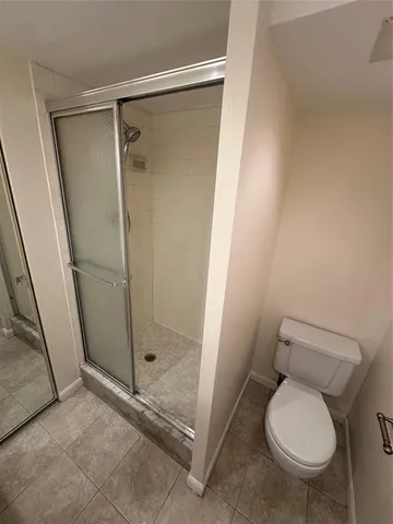 a bathroom with a granite countertop toilet and a shower