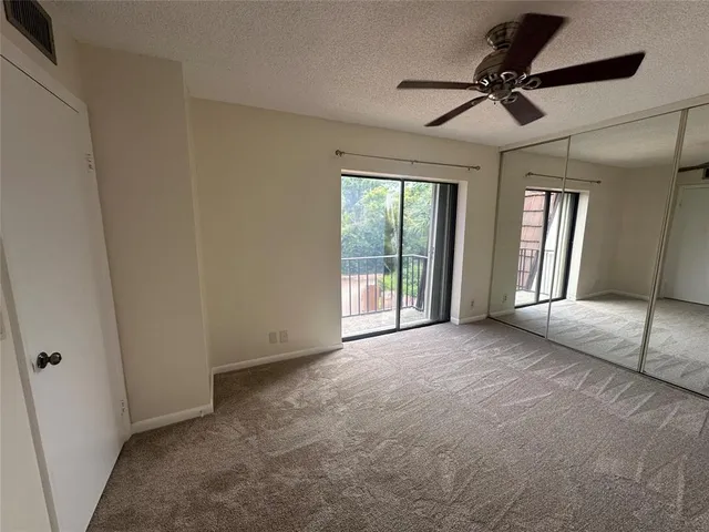 a view of empty room with window and ceiling fan