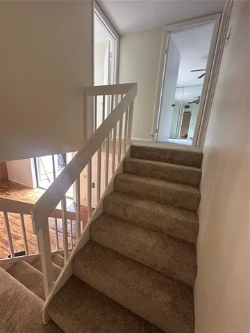 a view of staircase with lots of frames on wall