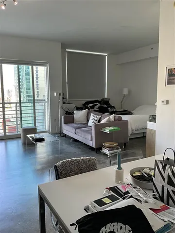 a living room with furniture gym equipment and a large window