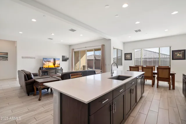 a living room with stainless steel appliances furniture and a kitchen view