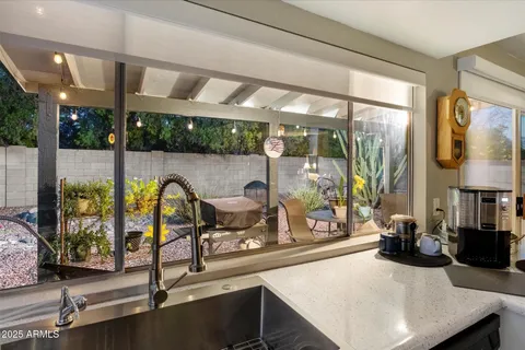 a kitchen with stainless steel appliances granite countertop a refrigerator a sink dishwasher a stove and white countertops with wooden floor