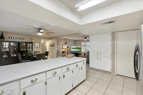 a kitchen with granite countertop cabinets a sink a dining table and chairs