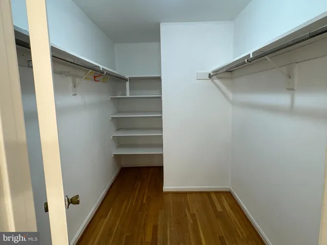 a view of walk in closet with wooden floor