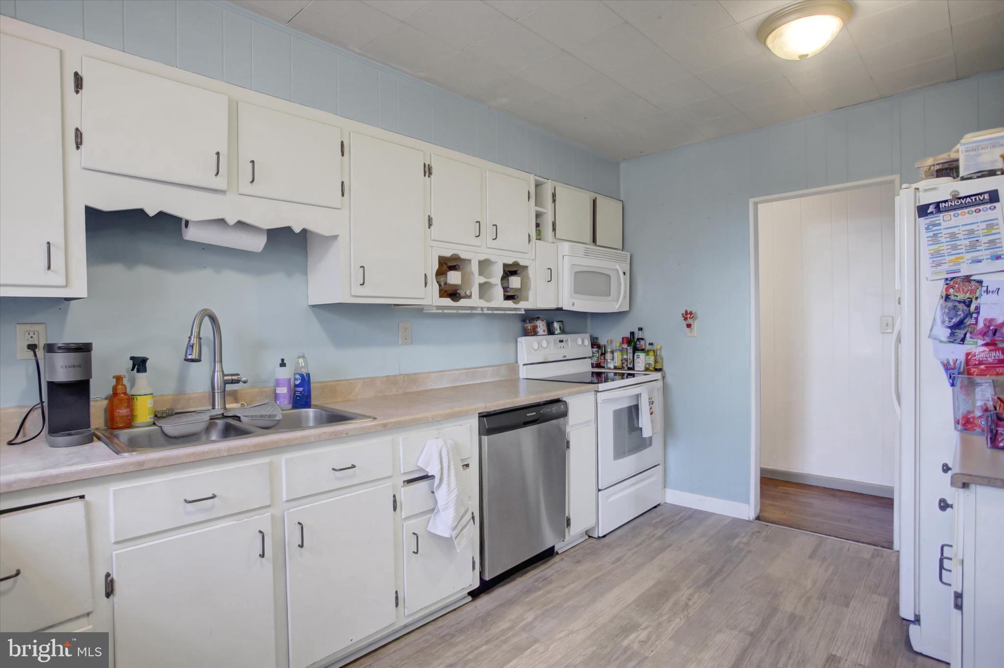 2688 Rocky Spring Road Chambersburg, PA 17201 - Photo 11 of 36 a kitchen with stainless steel appliances white cabinets sink and wooden floor
