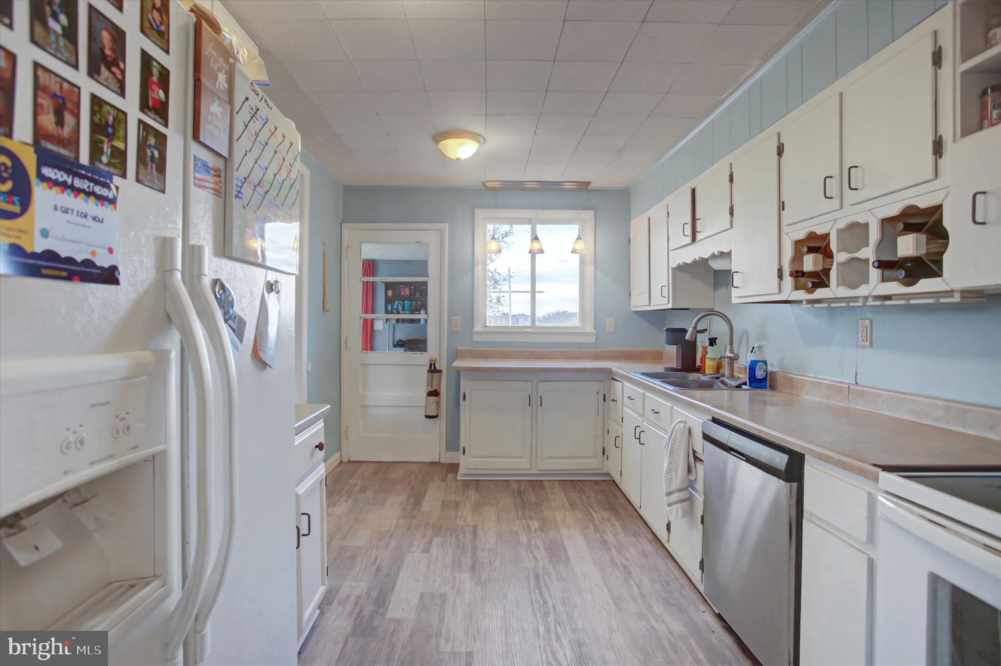 2688 Rocky Spring Road Chambersburg, PA 17201 - Photo 12 of 36 a kitchen with a white cabinets sink and wooden floor