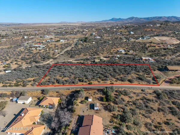 an aerial view of residential houses with outdoor space and trees