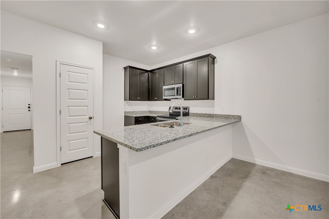 903 Wax Myrtle Court, Unit B Killeen, TX 76543 - Photo 4 of 13 a kitchen with a sink stove and refrigerator