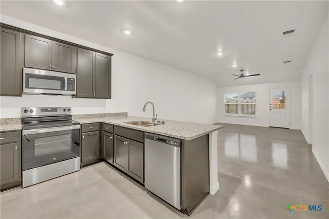 a kitchen with stainless steel appliances granite countertop a stove and a sink