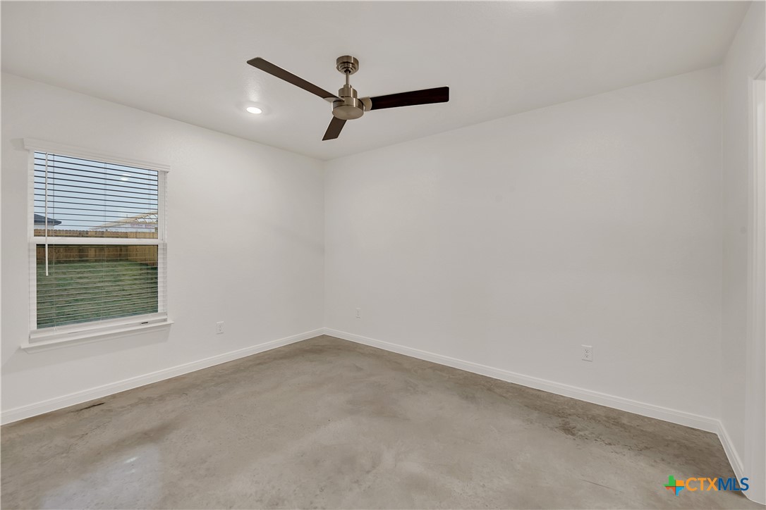903 Wax Myrtle Court, Unit B Killeen, TX 76543 - Photo 7 of 13 an empty room with a window and a ceiling fan