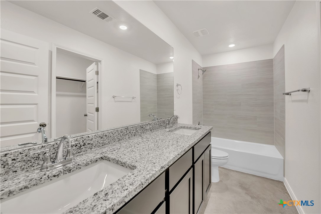 903 Wax Myrtle Court, Unit B Killeen, TX 76543 - Photo 10 of 13 a bathroom with a granite countertop sink a toilet and bathtub