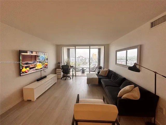 a spacious bedroom with a bed and a flat screen tv