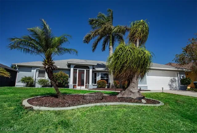 a front view of a house with a yard and potted plants