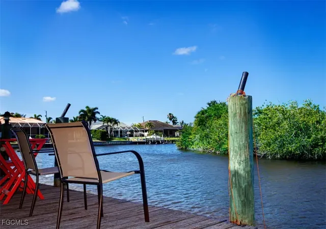 a view of a chairs and table in the patio next to a yard